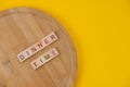 Dinner Menu Concept. Scrabble Letter Tiles On Wooden Table. Yellow Background