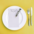 Dinner menu for a wedding or luxury evening meal. Table setting from above. Elegant empty plate, cutlery and flowers. Royalty Free Stock Photo