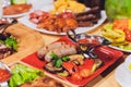 Dinner party food concept. Dinner table with grilled sausage, tortilla wraps, beer drink and different dishes on wooden Royalty Free Stock Photo