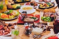 Dinner party food concept. Dinner table with grilled sausage, tortilla wraps, beer drink and different dishes on wooden Royalty Free Stock Photo