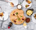 Dinner with pieces of pizza on board and plates Royalty Free Stock Photo