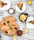 Dinner with pieces of pizza on board and plates Royalty Free Stock Photo