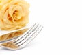 Dinner place setting. Knife and fork with yellow rose