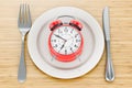 Dinner plate with alarm clock, 3D rendering Royalty Free Stock Photo