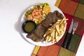 Dinner plate with beef salad and French fries. Traditional lunch in Latin America of meat with potatoes and chimichurri Royalty Free Stock Photo