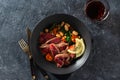 Dinner plate with beef steak with white beans, spinach and tomatoes on dark stone background top view with glass red wine Royalty Free Stock Photo