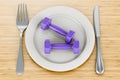 Dinner plate with fitness dumbbells, 3D rendering