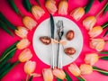 dinner plate with gold easter eggs, bow, tulips Royalty Free Stock Photo