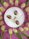 dinner plate with gold easter eggs, bow, tulips Royalty Free Stock Photo