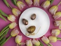 dinner plate with gold easter eggs, bow, tulips Royalty Free Stock Photo