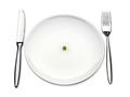 Dinner plate with one pea and fork and knife Royalty Free Stock Photo