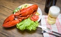 Dinner seafood lobster steamed on plate seafood with lemon salad lettuce vegetable and tomato / Beer glass on table Royalty Free Stock Photo