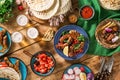 Dinner table with grilled sausage, tortilla, beer and different Royalty Free Stock Photo