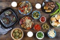 Dinner table with meat grill, bbq vegetables, salads, sauces, snacks and beer, top view Royalty Free Stock Photo