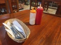 A dinner table in a restaurant with ketchup, mayo and cuttelry