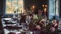 Dinner table setting in the warm glow of candlelight, tablescape featuring floral centerpiece, elegant burgundy glassware, and