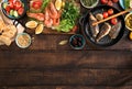 Dinner table with shrimp, fish grilled, salad, snacks with border