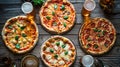 Dinner table with various delicious food. Italian pizza, beer, top view