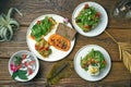 The dinner was served with different dishes - hummus with omelet, avocado toasts and yogurt with chia seeds on a wooden table. Top