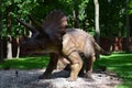 Dino Park Triceratops huge dinosaur of Jurassic era walks in the forest in summer on a sunny day Royalty Free Stock Photo