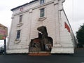 Dinosaur breaking through wall of upside-down White House