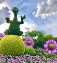 Dinosaur character purple flowers green bushes