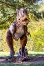 Dinosaur model in the park. Giant tyrannosaurus at an exhibition in the park on a summer sunny day Royalty Free Stock Photo