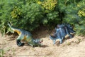 Toy Stegosaurus and Tyrannosaurus Rex are standing on the ground. Prehistoric history