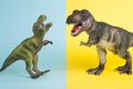 2 dinosaurs fighting on a yellow and blue background