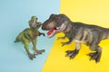 2 dinosaurs fighting on a yellow and blue background