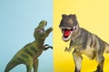 2 dinosaurs fighting on a yellow and blue background