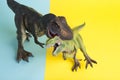 2 dinosaurs fighting on a yellow and blue background