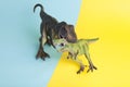 2 dinosaurs fighting on a yellow and blue background