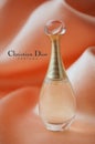 Dior perfume from Christian Dior in a miniature bottle on satin background