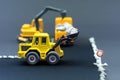 Diorama road construction with yellow construction machinery models