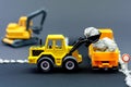 Diorama road construction with yellow construction machinery models