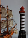 Back Angle View Of Scale Model Of Sailing Ship Toward The Toy Lighthouse Tower Royalty Free Stock Photo