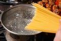 Dip spaghetti into boiling water in a saucepan. Pasta cooking