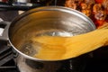 Dip spaghetti into boiling water in a saucepan. Pasta cooking