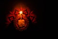 Dipawali Concept - top-view of a glowing Earthen Lamp over a Rangoli design on a black surface with copy space on the right