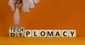 Diplomacy or techplomacy symbol. Businessman turns cubes and changes the concept word diplomacy to techplomacy. Beautiful orange