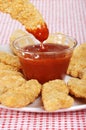 Dipping chicken finger in BBQ sauce Royalty Free Stock Photo
