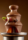 Dipping fresh fruit into a chocolate fountain Royalty Free Stock Photo