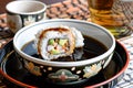 dipping sushi into soy sauce bowl with sake cup beside Royalty Free Stock Photo