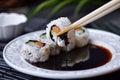 dipping sushi into soy sauce with chopsticks Royalty Free Stock Photo