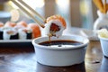 dipping sushi into soy sauce with chopsticks Royalty Free Stock Photo