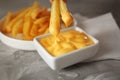 Dipping tasty fries into cheese sauce in bowl Royalty Free Stock Photo