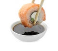 Dipping tasty sushi into soy sauce isolated on white Royalty Free Stock Photo