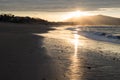 Direct golden sunset`s sunlight on a scenic sandy beach in hendaye in dramatic cloudy atmosphere, basque country, france Royalty Free Stock Photo