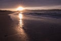 Direct golden sunset`s sunlight on a scenic sandy beach in hendaye in dramatic cloudy atmosphere, basque country, france Royalty Free Stock Photo